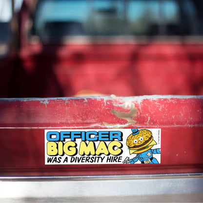 A vinyl bumper magnet reading "OFFICER BIG MAC WAS A DIVERSITY HIRE" on red truck tailgate.