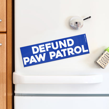 A vinyl bumper magnet reading "DEFUND PAW PATROL" on a white fridge.