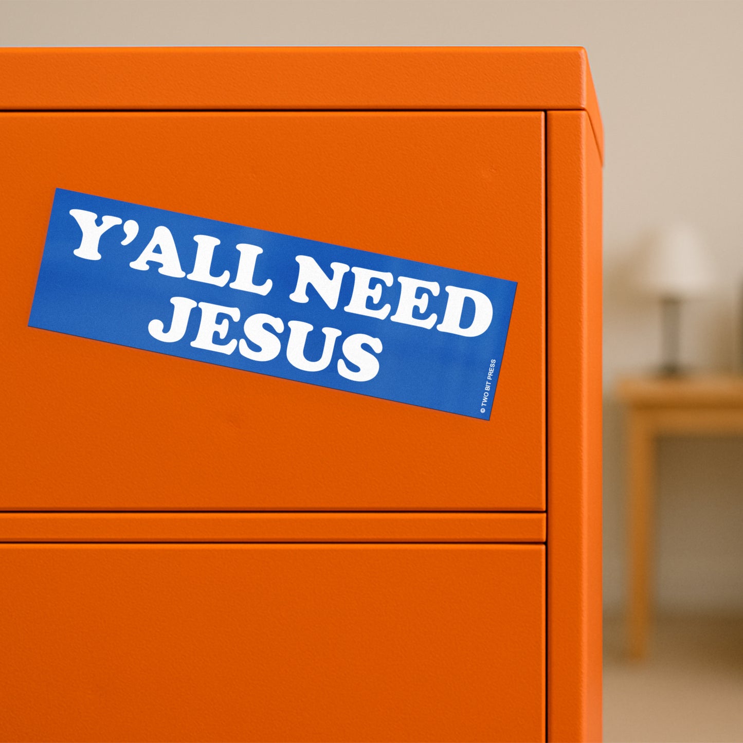 A vinyl bumper magnet reading "Y'ALL NEED JESUS" on orange filing cabinet.
