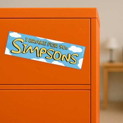 A vinyl bumper magnet showing clouds and the text "I BRAKE FOR 90s SIMPSONS" on orange filing cabinet.