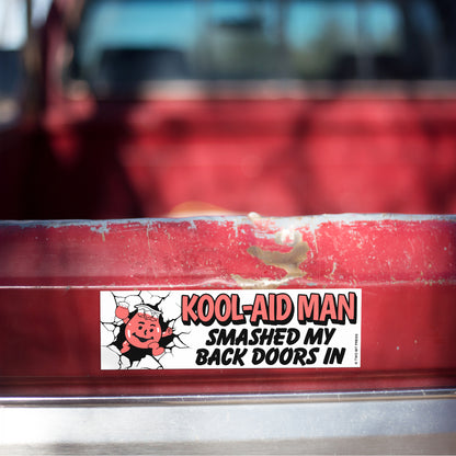 A vinyl bumper magnet showing the Kool-Aid Man and the text "KOOL-AID MAN SMASHED MY BACK DOORS IN" on red truck tailgate.