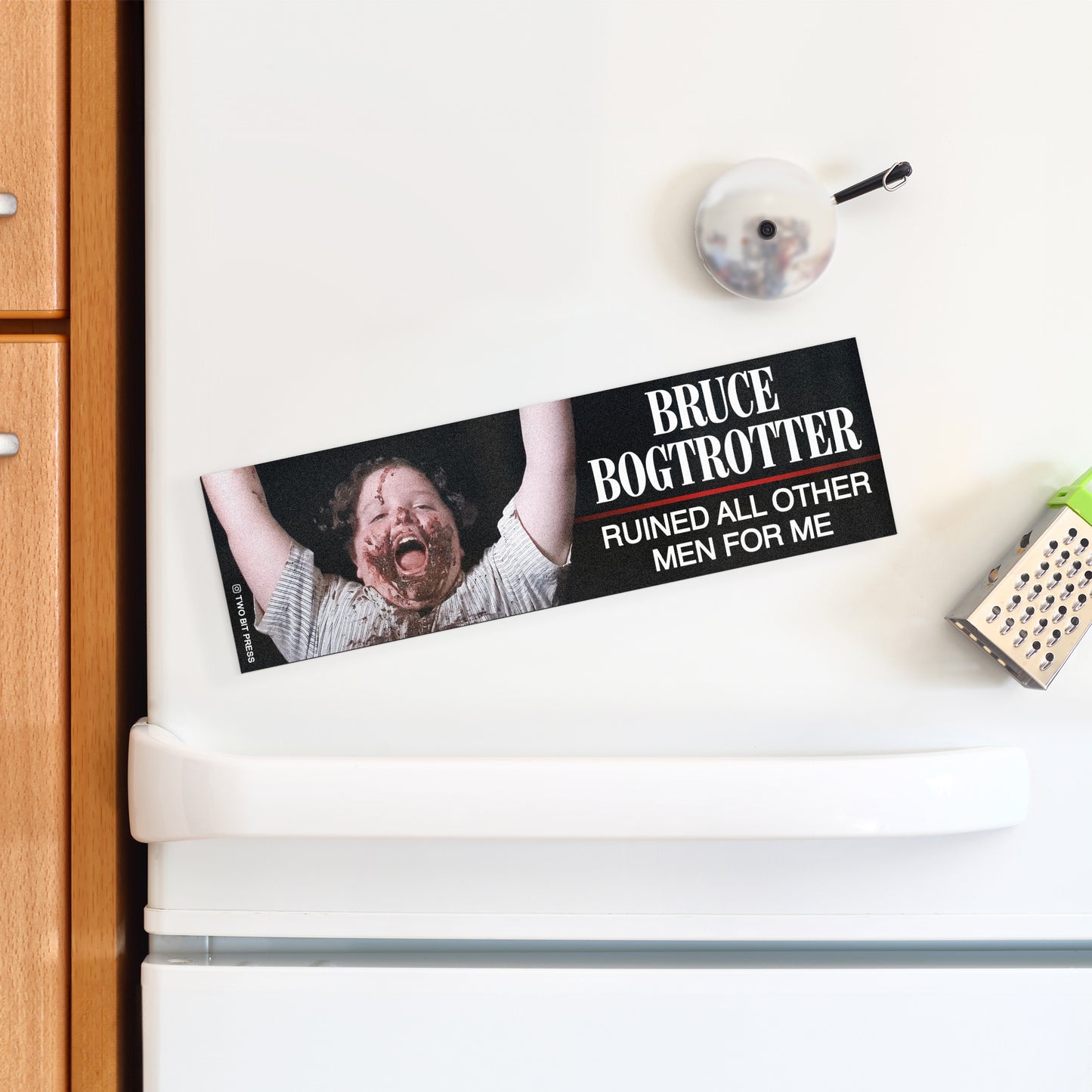 A bumper magnet showing Bruce Bogtrotter and the text "BRUCE BOGTROTTER RUINED ALL OTHER MEN FOR ME" on a white fridge.