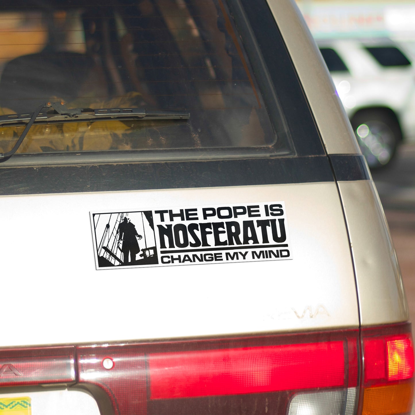 A vinyl bumper magnet showing Nosferatu and the text "THE POPE IS NOSFERATU CHANGE MY MIND" on gold minivan.