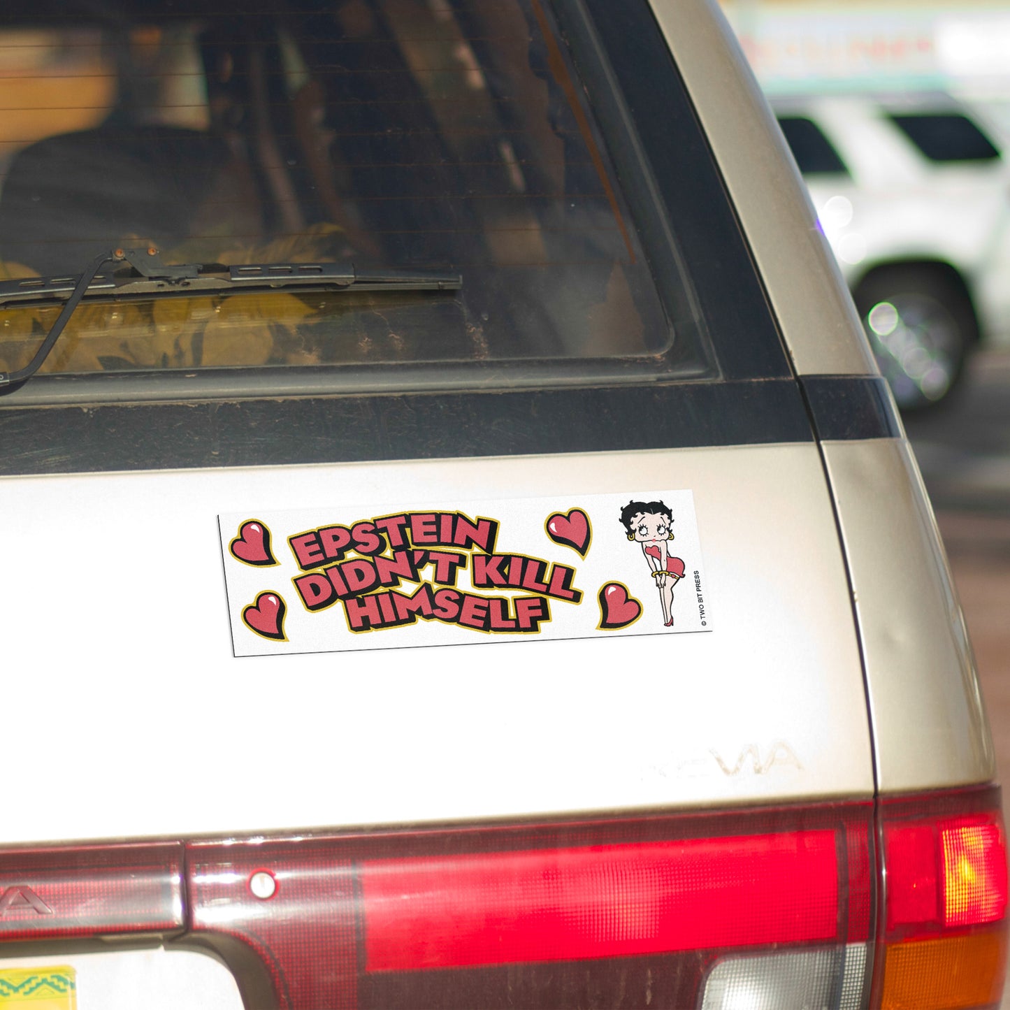 A vinyl bumper magnet showing Betty Boop and the text "EPSTEIN DIDN'T KILL HIMSELF" on gold minivan.