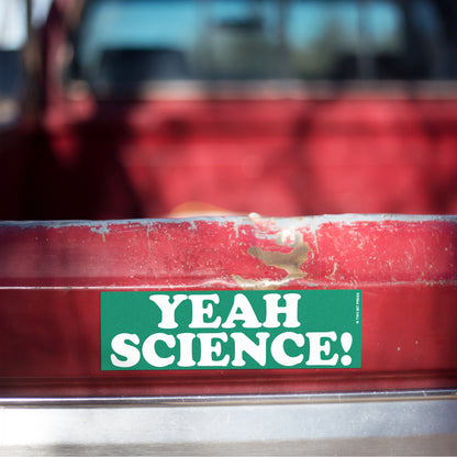 A vinyl bumper magnet reading "YEAH SCIENCE!" on red truck tailgate.