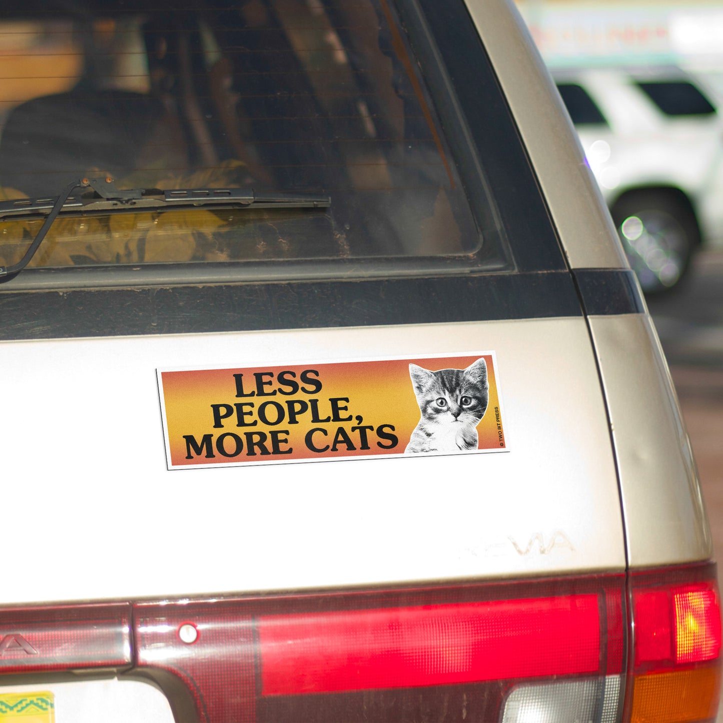 A vinyl bumper magnet showing a cat and the text "LESS PEOPLE, MORE CATS" on gold minivan.
