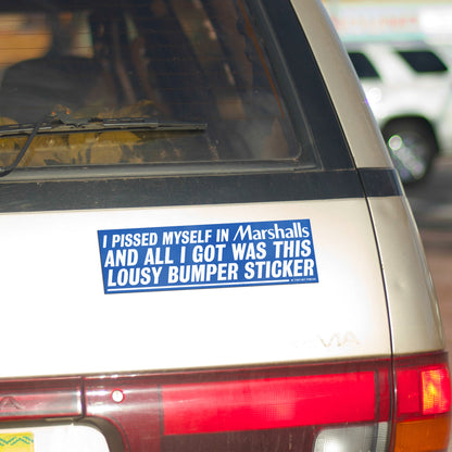 A bumper magnet reading "I PISSED MYSELF IN Marshalls AND ALL I GOT WAS THIS LOUSY bumper magnet" on gold minivan.