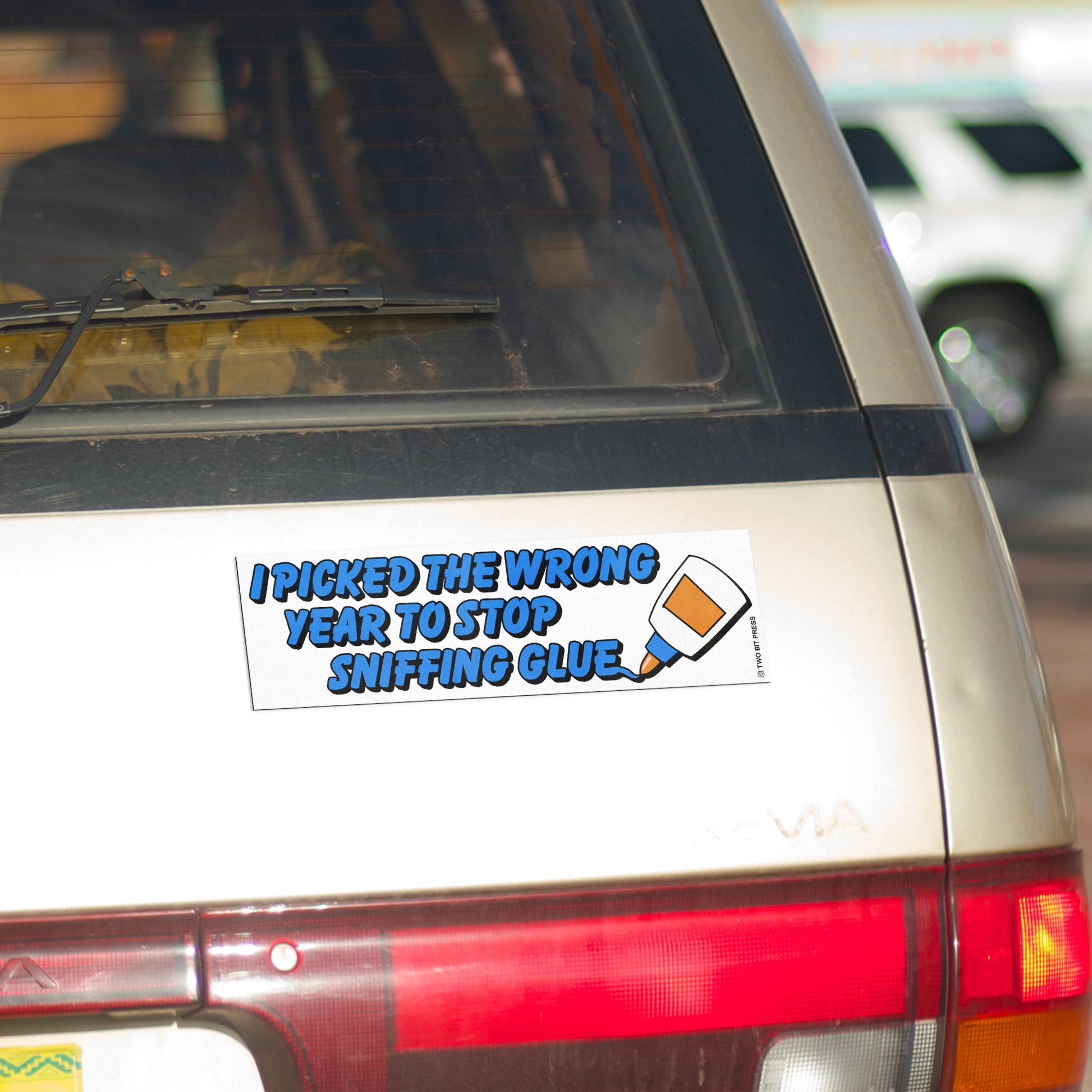 A vinyl bumper magnet reading "I PICKED THE WRONG YEAR TO SNIFFING GLUE" on gold minivan.