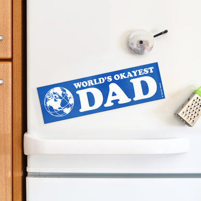 A vinyl bumper magnet showing a globe and the text "WORLD'S OKAYEST DAD" on a white fridge.