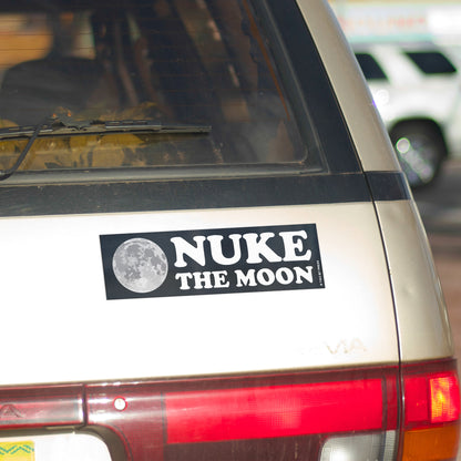 A vinyl bumper magnet showing the moon and the text "NUKE the MOON" on gold minivan.