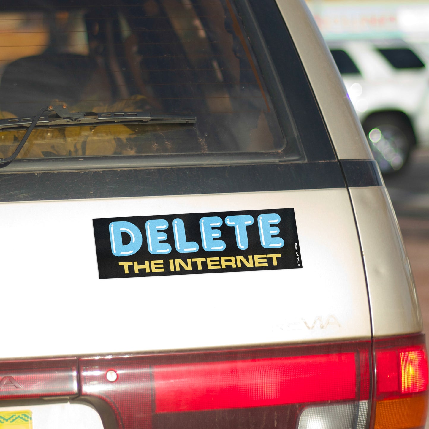 A vinyl bumper magnet reading "DELETE THE INTERNET" on gold minivan.
