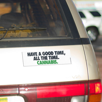 A vinyl bumper magnet reading "HAVE A GOOD TIME, ALL THE TIME. CANNABIS" on gold minivan.
