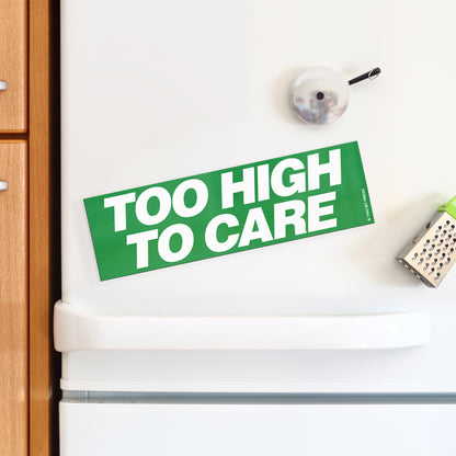 A vinyl bumper magnet reading "TOO HIGH TO CARE" on a white fridge.
