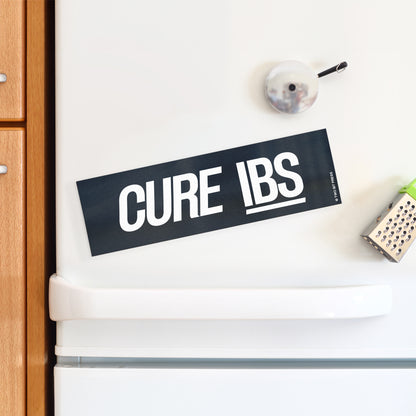 A vinyl bumper magnet reading "CURE IBS" on a white fridge.