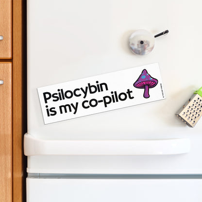 A vinyl bumper magnet showing a mushroom and the text "Psilocybin is my co-pilot" on a white fridge.