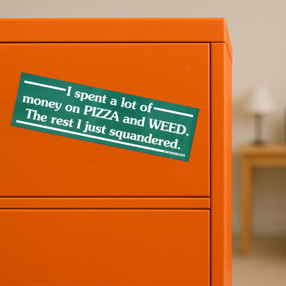A vinyl bumper magnet reading "I spent a lot of money on PIZZA and WEED. The rest I just squandered." on orange filing cabinet.