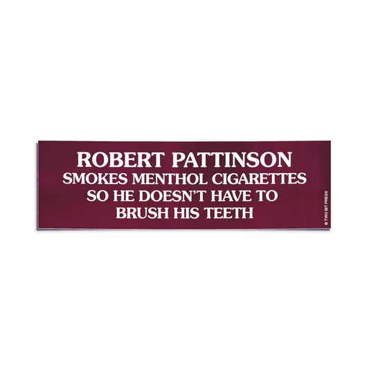 A bumper sticker reading "ROBERT PATTINSON SMOKES MENTHOL CIGARETTES SO HE DOESN'T HAVE TO BRUSH HIS TEETH" on white surface.